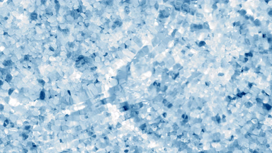 Wave making ripples on water surface over blue crystal minerals