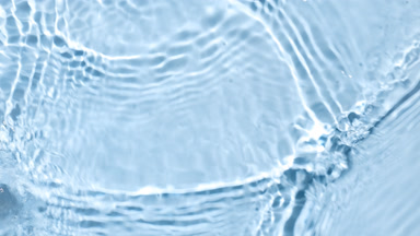 Water waves crossing and splashing against blue background