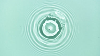 Two drops fall down on water surface in turn creating rings