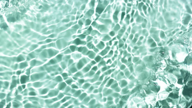 Water waves and ripples crossing against green mint background
