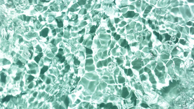 Waves cross each other and drops fall on water creating ripples