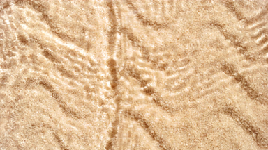 Water waves crossing and splashing on brown sugar background