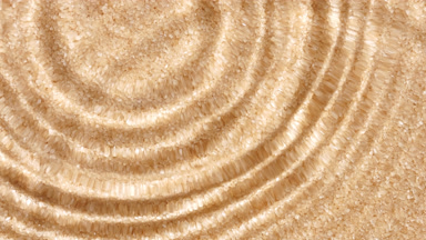 Multiple water drops falling on surface over brown sugar texture