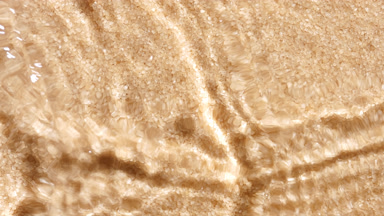 Water waves crossing and splashing on cane sugar crystals