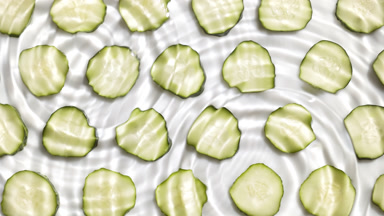 Drops falling in water making circles over cucumber slices