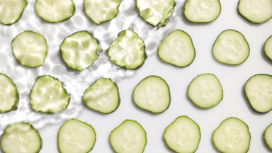 Wave making ripples on water surface over cucumber slices