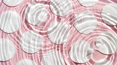 A lot of clear drops fall down on water surface creating rings