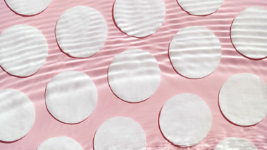 Stream flows up creating water ripples on cotton pads background