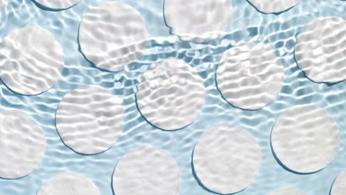 Single wave of water creates ripples on pale blue background