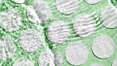 Water waves and ripples crossing against cotton pads on green bg
