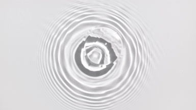 Water drop makes water ripples on water surface on white bg