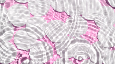 Drops falling in water making circles over cotton pads on pink