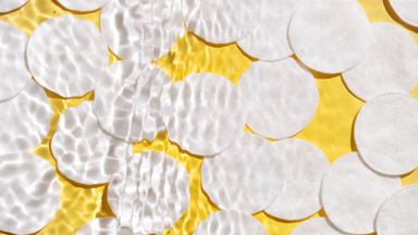 Splashing wave makes ripples over cotton pads on yellow