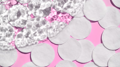 Wave of water creates ripples spontaneously on pink background