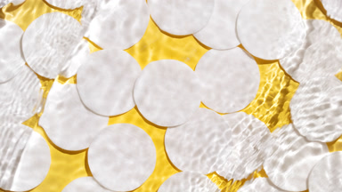 Waves and ripples crossing against cotton pads on yellow bg
