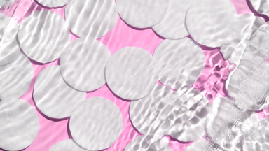 Water waves and ripples crossing against cotton pads on pink bg