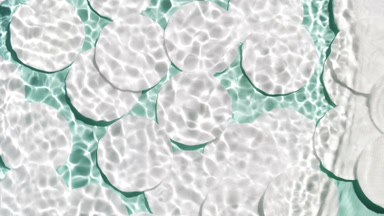 Single wave of water creates ripples on pale green background