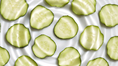 Drop makes rings on water surface over cucumber slices
