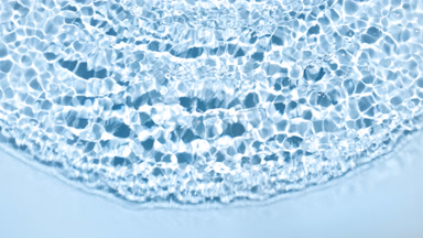 Wave makes ripples and splashes on water surface on blue bg