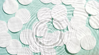 Drops fall down on water creating rings and waves create ripples