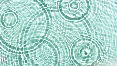 Drops falling in water with wave on green mint bg