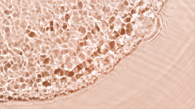 Multiple water drops falling in water with waves on beige bg