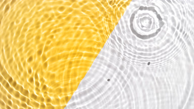 Drops falling in water making circles on yellow and white bg