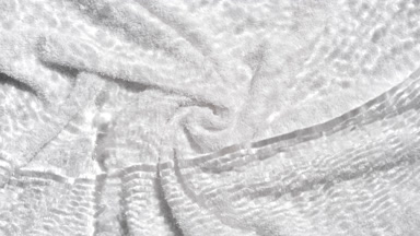Wave of water rippling spontaneously on white towel background
