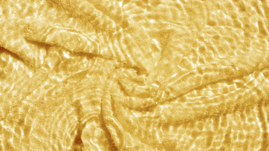 Drops falling in water making circles over yellow terry towel bg