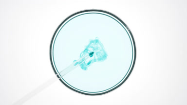 Dropper injects cyan liquid into light blue one in Petri dish