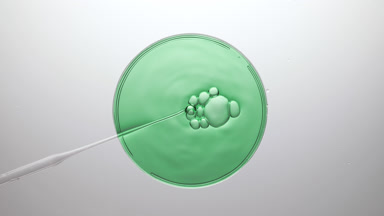 Bubbles come out from dropper and float on green fluid bursting