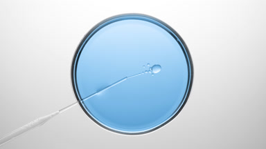 Chemical dropper injects oil into blue liquid in Petri dish