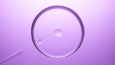 Lab dropper injecting oil into transparent liquid in Petri dish