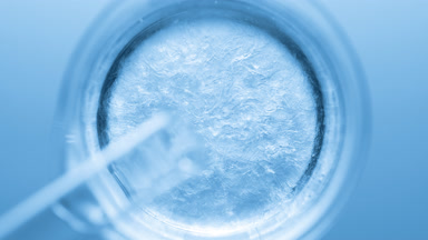 Glycerin pouring into beaker with water creates ripples
