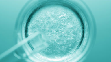 Glycerin pouring into beaker with water creates ripples