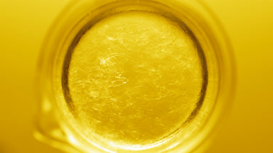 Glycerin pouring into beaker with water creates ripples