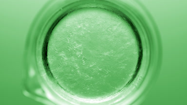 Glycerin pouring into beaker with water creates ripples