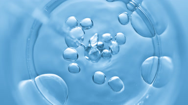 Bubbles come out from dropper and float on clear fluid in beaker
