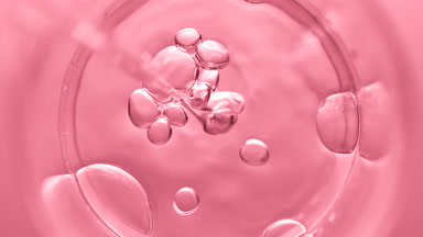 Bubbles come out from dropper and float on clear fluid in beaker