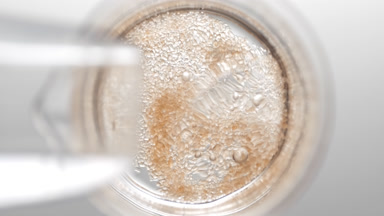 Cane sugar fall down into liquid in flask creating bubbles
