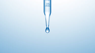 Transparent fluid is dripped from graduated lab dropper