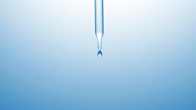 Clear drops are falling down from chemical dropper