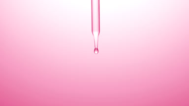 Clear drops are falling down from chemical dropper