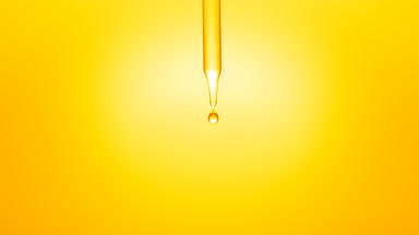 Clear drops are falling down from chemical dropper