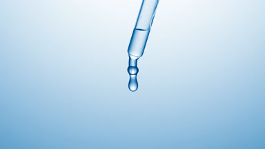 Transparent drops are falling down from chemical dropper