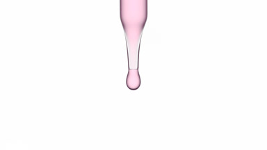Drop of purple transparent fluid is falling down from dropper