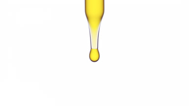 Yellow drop is dripping down from the pipette