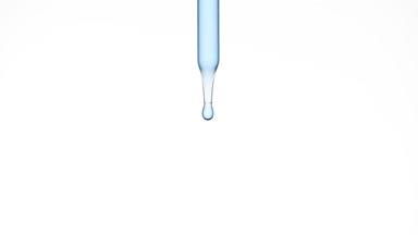 Drops of blue clear fluid are falling down from lab dropper