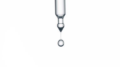 Drop of hyaluronic acid is falling down from pipette