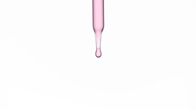 Drops of rose water are falling down from lab dropper